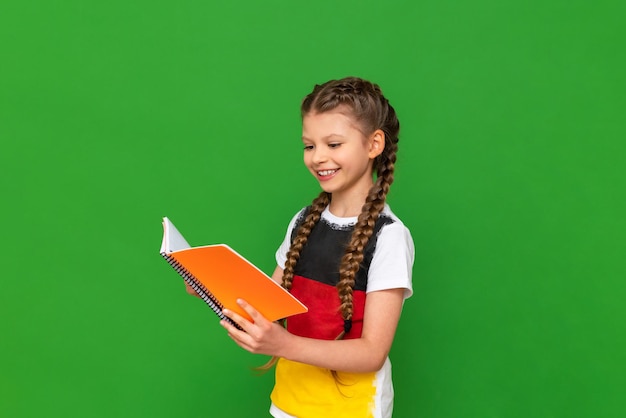 A little girl with a german flag on her tshirt is studying a\
foreign language textbook education in germany and obtaining a\
certificate