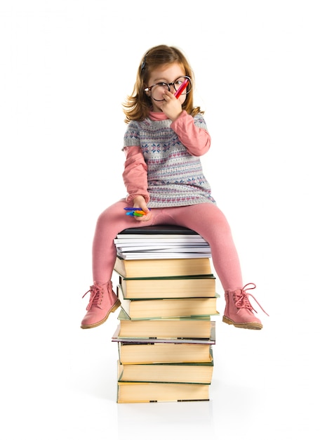 Foto bambina con gli occhiali seduto sui libri. di nuovo a scuola