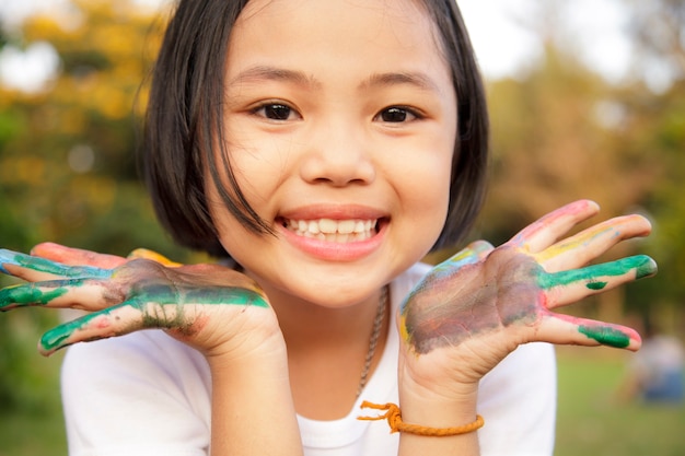 Little girl with hands painted in colorful paint