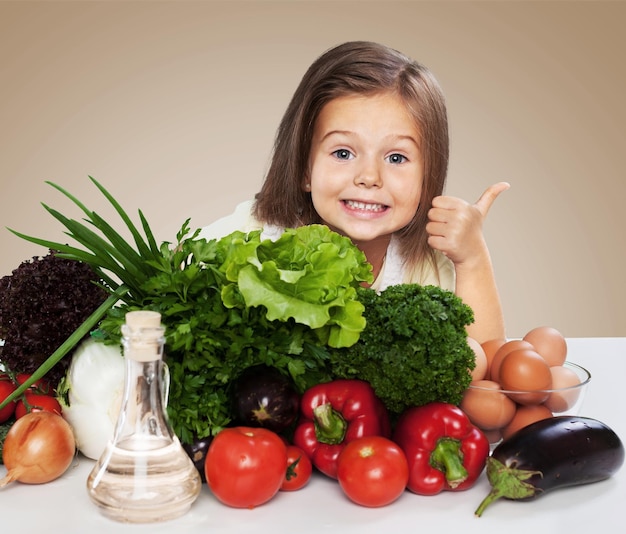 Little girl with healthy food showing thumb up