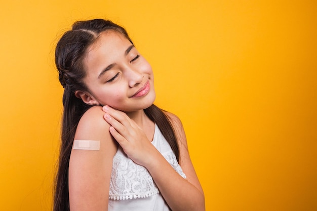 Foto bambina con gli occhi chiusi sorridente dopo aver ricevuto una vaccinazione.