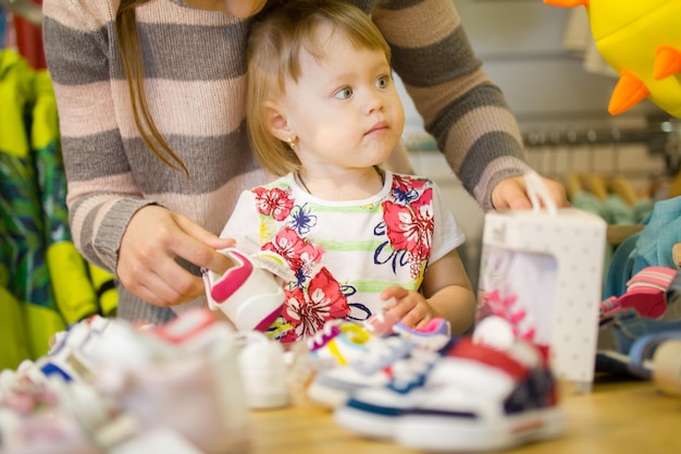 Little girl with her mom at the childrens clothing store