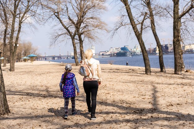 Little girl with her mom at the city pier in the spring