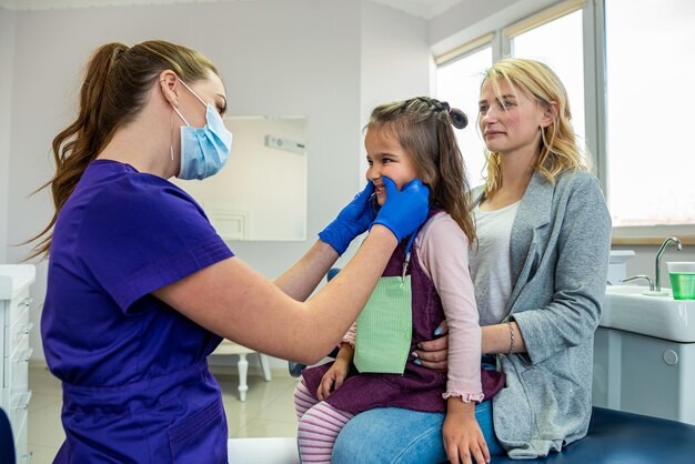 母親と一緒に小さな女の子が小児歯科医を訪ねる