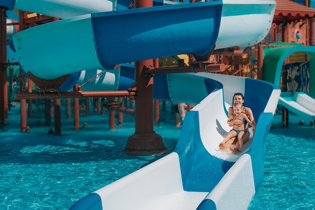 Little girl with her mother on the water slide