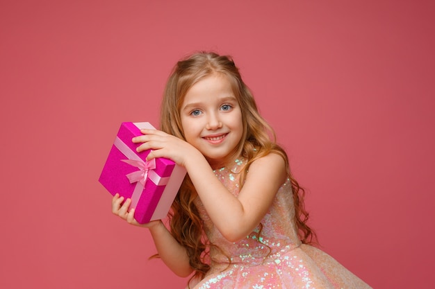 Little  girl with holiday gift on a colored