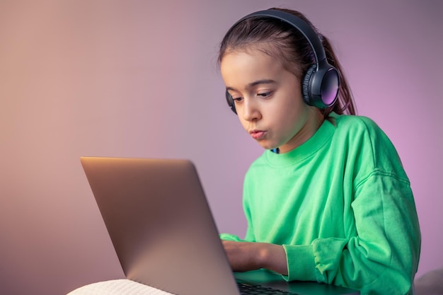 Little girl with laptop plays games concept of game addiction