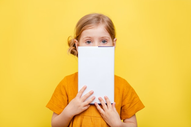 A little girl with light hair on yellow