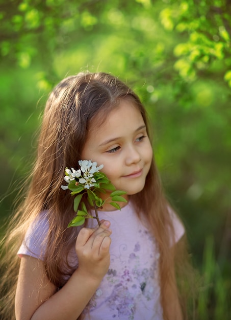 사진 자연의 꽃 나무 근처에 긴 머리를 가진 어린 소녀