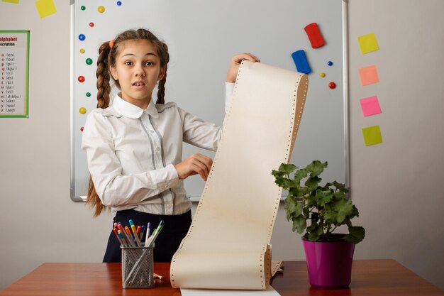 little girl with a long to do list in her hands in the classroom