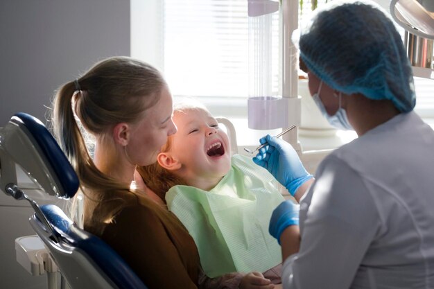 Little girl with mommy in dentist room, close up