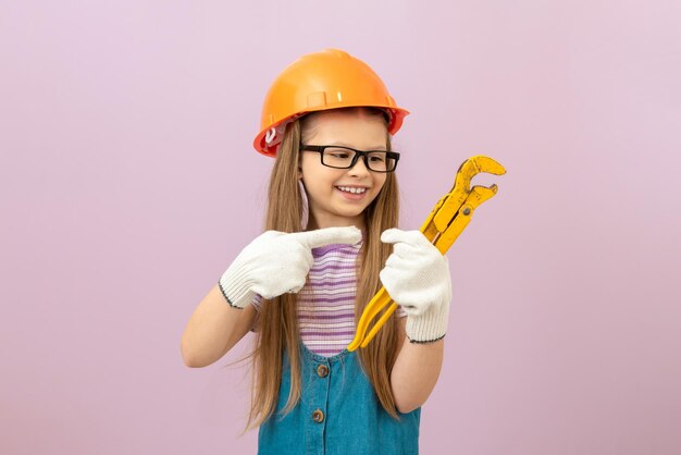 A little girl with a monkey wrench. Repair and construction work.