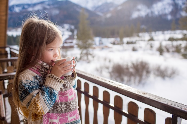 Little girl with a mug of hot tea