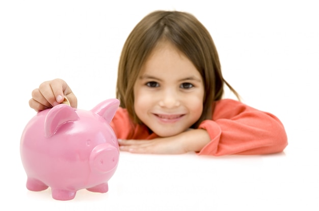 little girl with piggy bank isolated on white