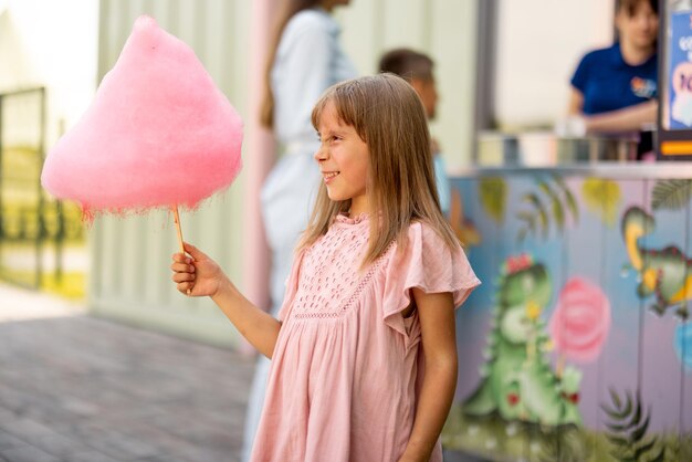 Foto ragazzina con zucchero di cotone rosa