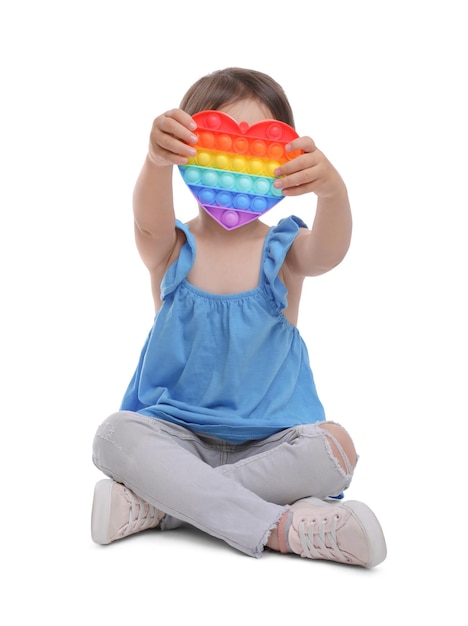 Маленькая девочка с поп-игрушкой на белом фоне