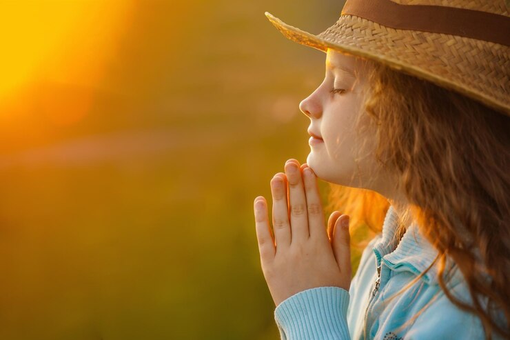 Little girl with praying in outdoors