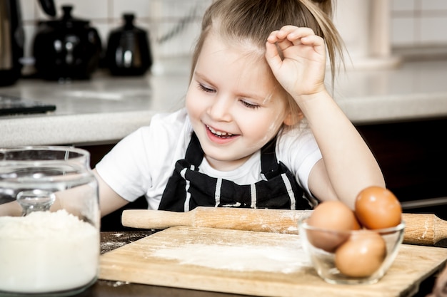 Little girl with  preparing bake homemade holiday pie in kitchen. 