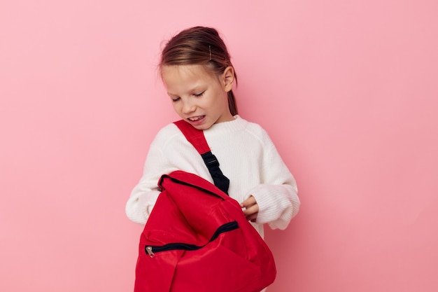 Little girl with a red backpack fun isolated background