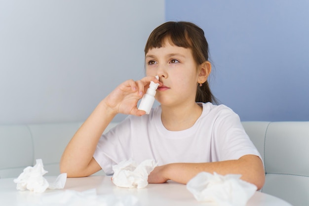 Little girl with runny nose does nasal spray irrigations to stop allergic rhinitis and sinusitis