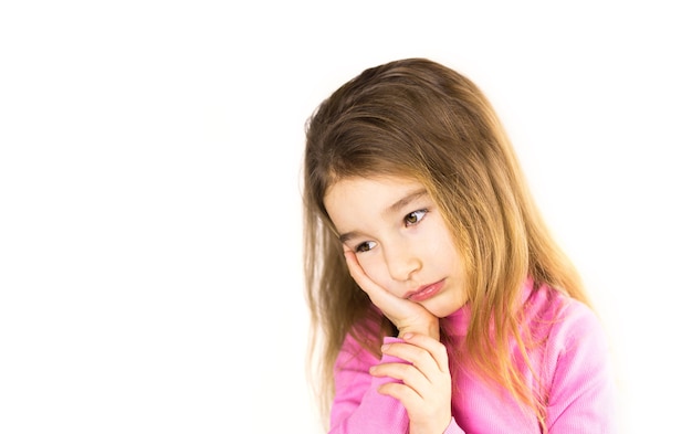 Маленькая девочка с грустным лицом держит рукой за щеку - болит зуб