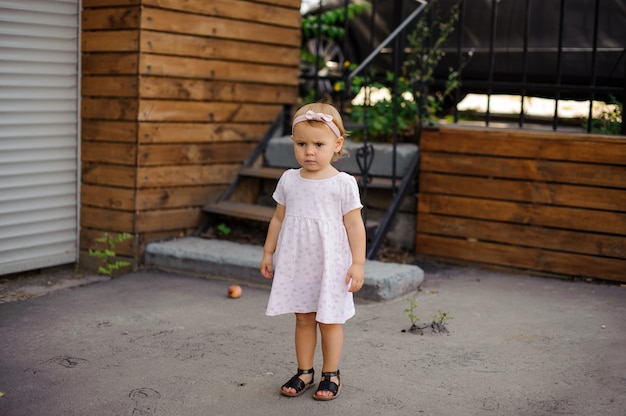 Little girl with a serious look dressed in cute pink dress