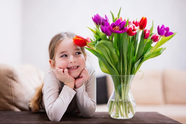 Little girl with spring tulip bouquet Holiday decor with flowers colorful tulips