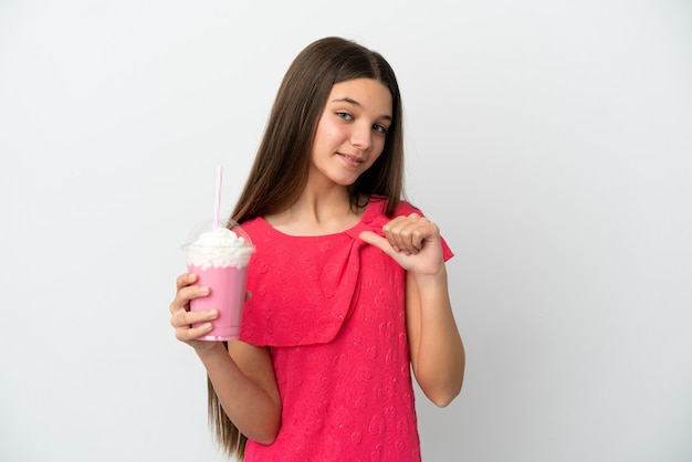 Little girl with strawberry milkshake over isolated white wall proud and self-satisfied