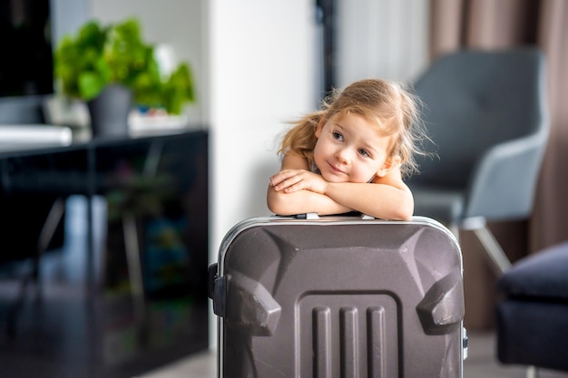 Little girl with suitcase baggage luggage ready to go for traveling on vacation