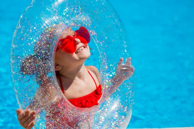 Bambina con un cerchio di nuoto in piscina