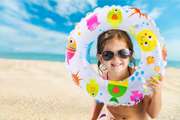 Foto bambina con anello di nuoto sulla spiaggia