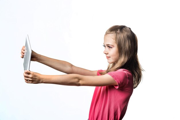 Little girl with a tablet computer on a white background Emotions of the child