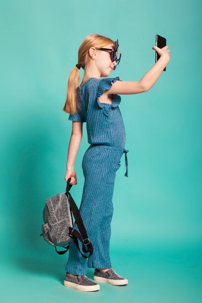 Little girl with a tail in stylish clothes and sunglasses