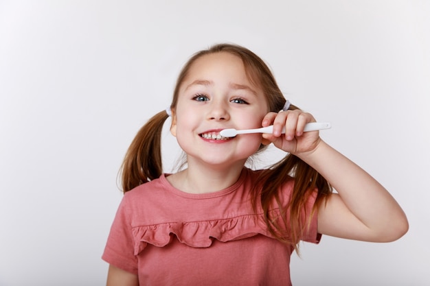 Bambina con spazzolino da denti lavarsi i denti