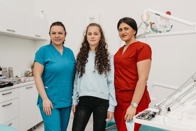 Little girl with a two dentist in a modern office after an examination