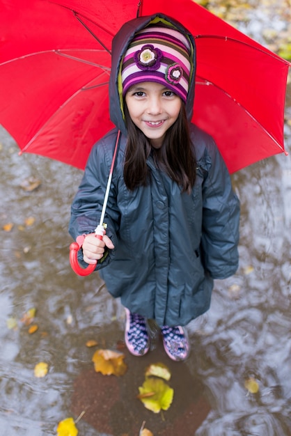 Photo little girl with umbrella at the rainy day