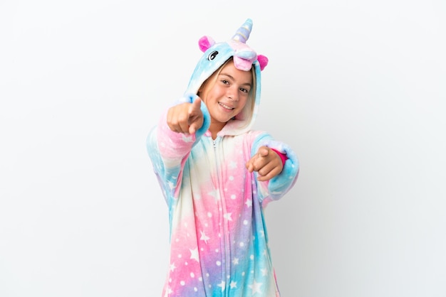 Photo little girl with unicorn pajamas isolated on white background points finger at you while smiling