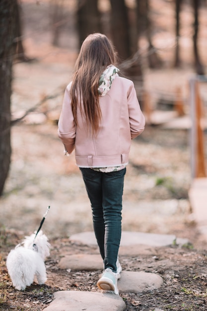 白い子犬を持つ少女。女の子の手の中の子犬