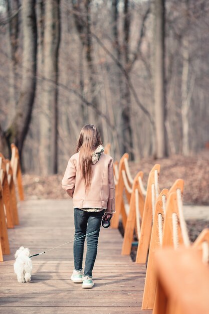 白い子犬を持つ少女。女の子の手の中の子犬