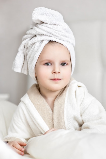 Bambina con un asciugamano bianco in testa