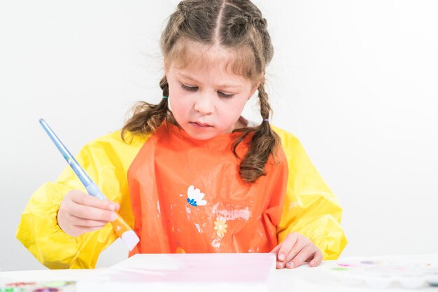 Little girl working on an art project with acrylic paint at homeschool.