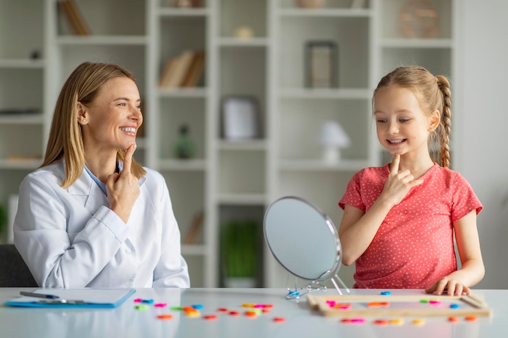 Photo little girl working on pronunciation with logopedist lady during meeting in office