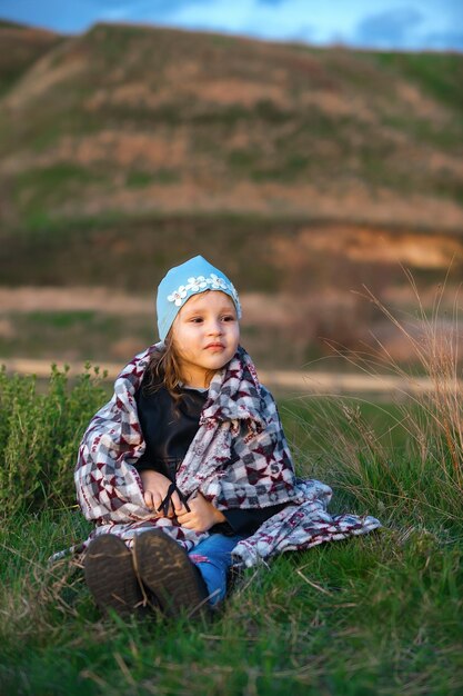 little girl wrapped in a blanket on an evening family walk