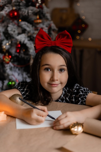 little girl writes a letter with wishes to Santa Claus