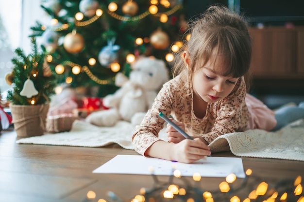 Bambina che scrive una lettera a babbo natale