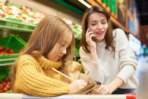 小さな女の子の買い物リストを書く