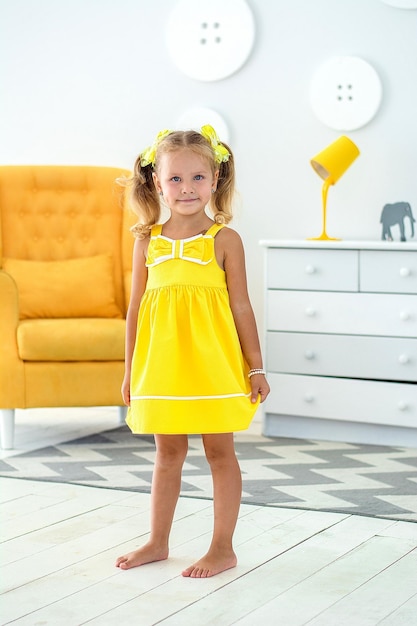 어린이 방에 노란 드레스를 입은 어린 소녀