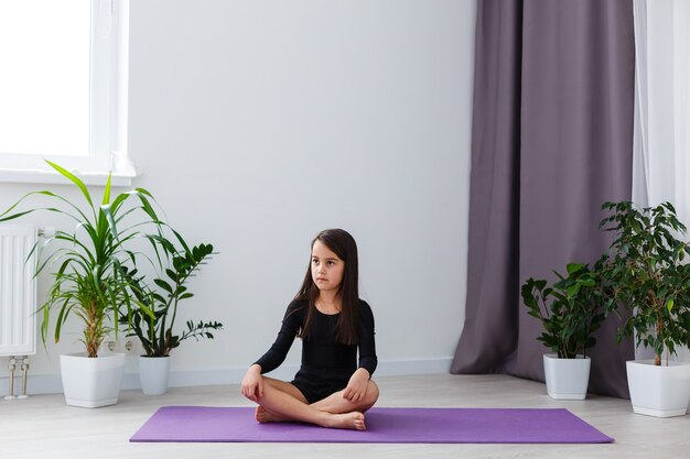 little girl do yoga at apartment