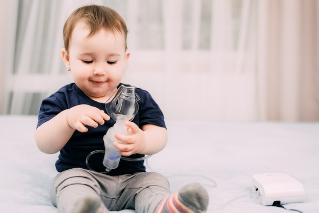 a little girl yourself holding the mask of the nebulizer, making inhalation and treated