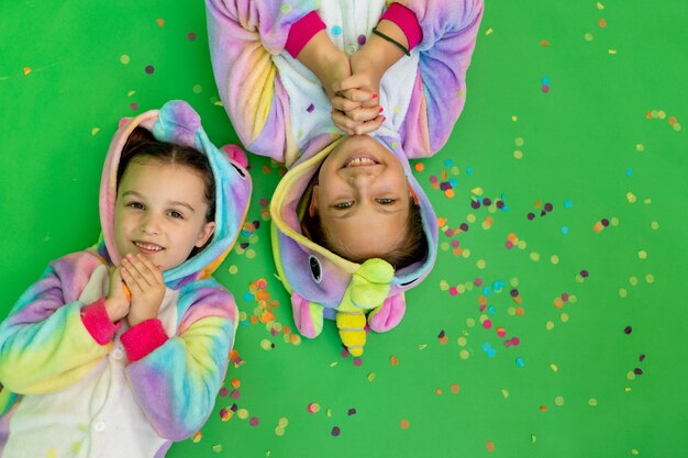 Little girls in bright costumes on a green background